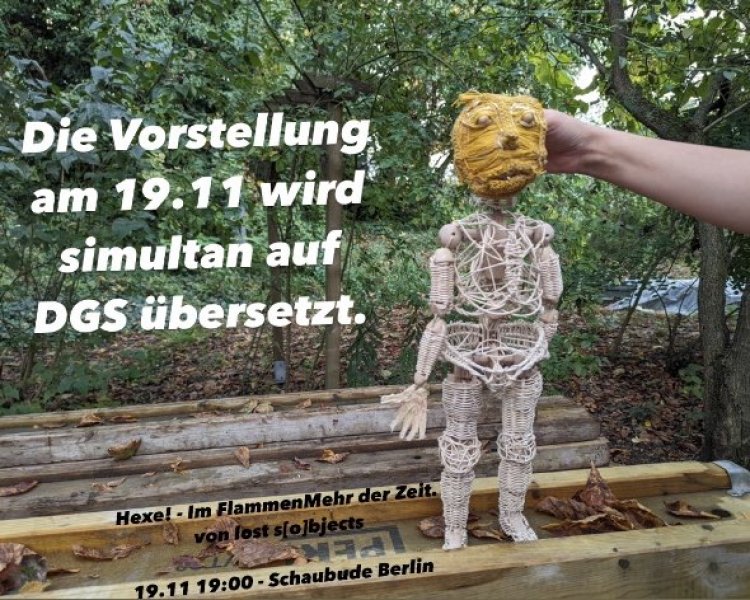 Eine Puppe aus Rattan steht auf einem Holzbrett im Wald. Sie tr&auml;gt eine gelbe Maske. Links neben ihr steht: &quot;Die Vorstellung am 19.11 wird simultan auf DGS &uuml;bersetzt.&quot; | © Artemiy Shokin